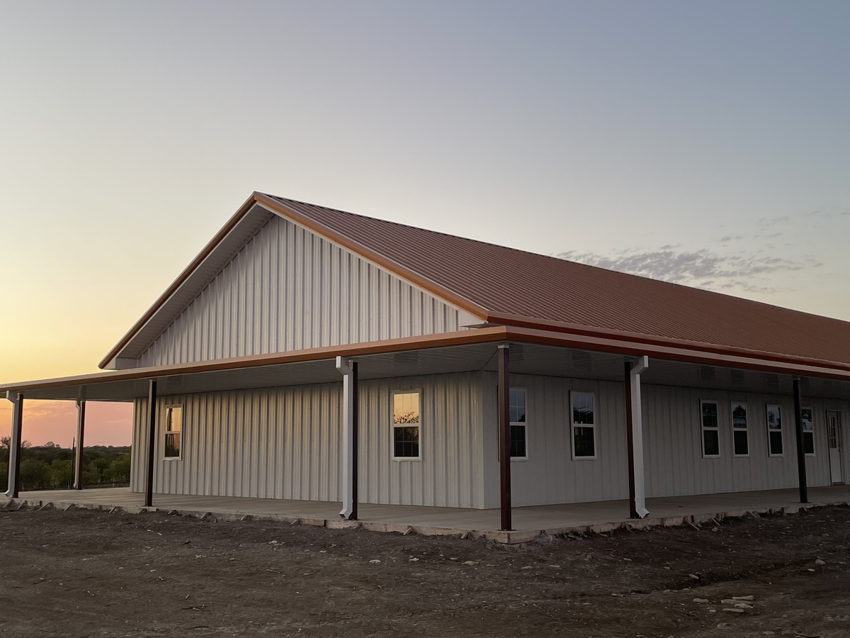 Finished metal barndominium with wraparound porch in North Texas